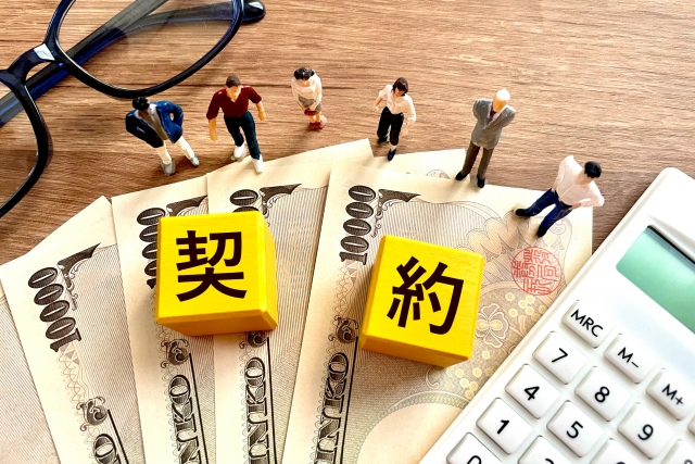 一万円札の上に契約と書いてあるキューブの写真