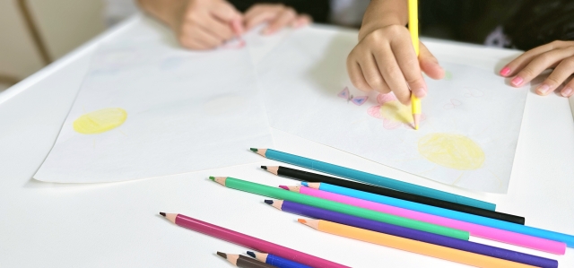 色鉛筆でお絵描きをしている子供の写真