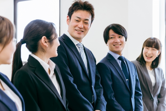 仲間と笑顔でいるデザイナーの写真