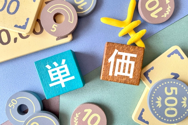 単価と書かれたキューブの周りに小銭が置いてある写真