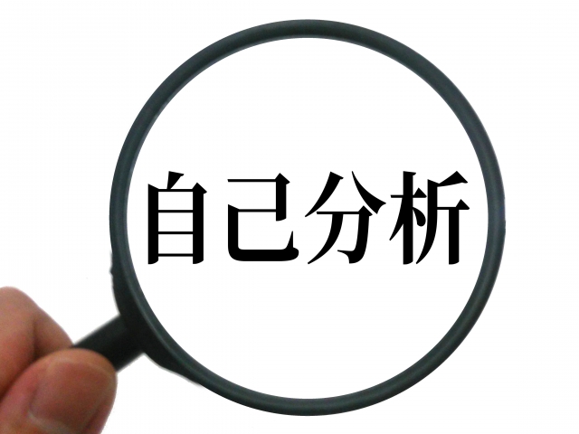 虫眼鏡で自己分析という文字を見ている写真