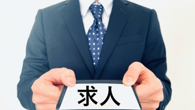 求人と書かれた紙を差し出す就職活動中の男性の写真