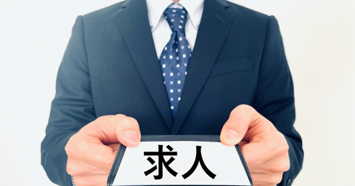 求人と書かれた紙を差し出す就職活動中の男性の写真