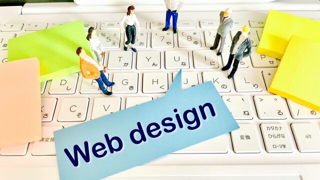 パソコンのキーボードの上にWebデザインと書いてある紙が乗っている写真